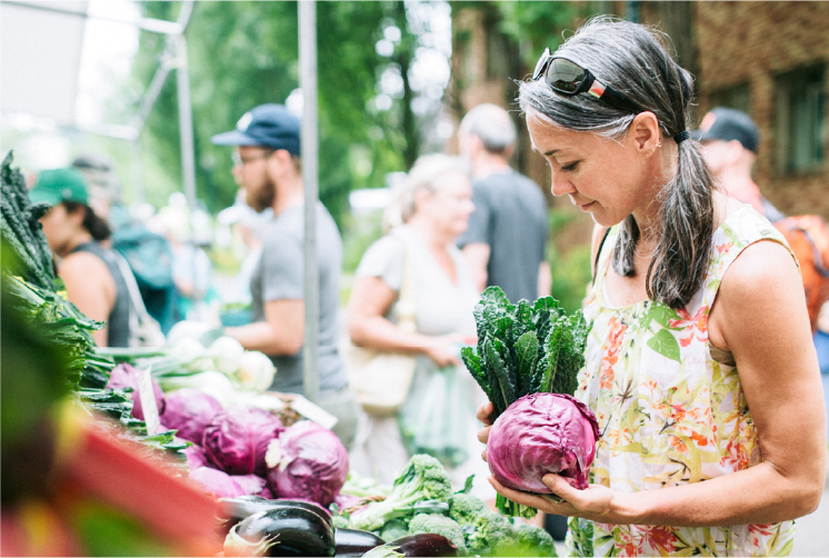 A lady buying vegetables at a market